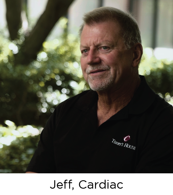 Close-up of a middle-aged man, white with short hair, wearing a black polo shirt and looking off camera