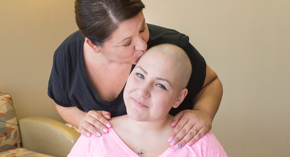 Mom Pamela leans down to kiss daughter Lizzie