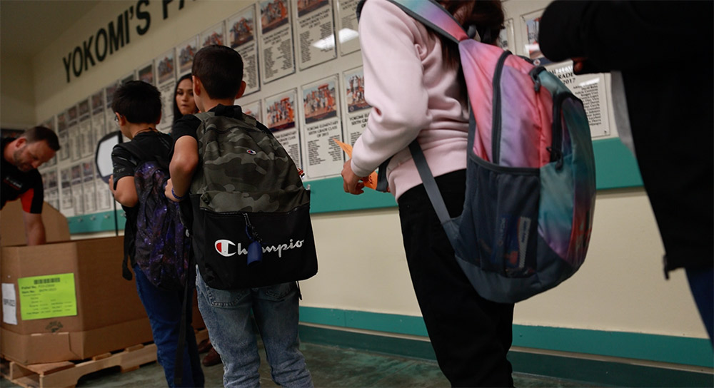 Students stand in line for food